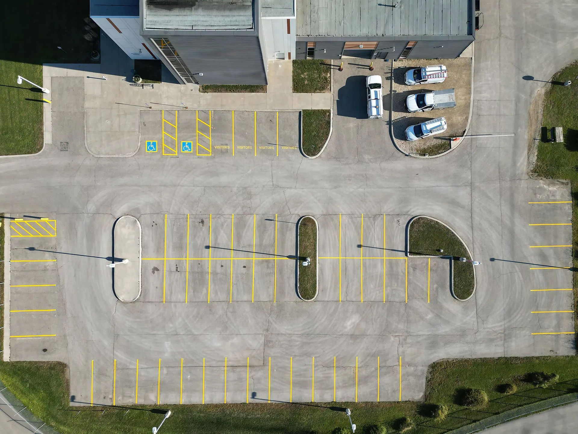 Parking Spaces: The lot is marked with bright yellow lines, delineating numerous individual parking spaces.
